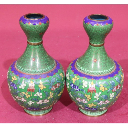 848 - A pair of Oriental cloisonné round bulbous thin necked vases on green ground with multicoloured flor... 