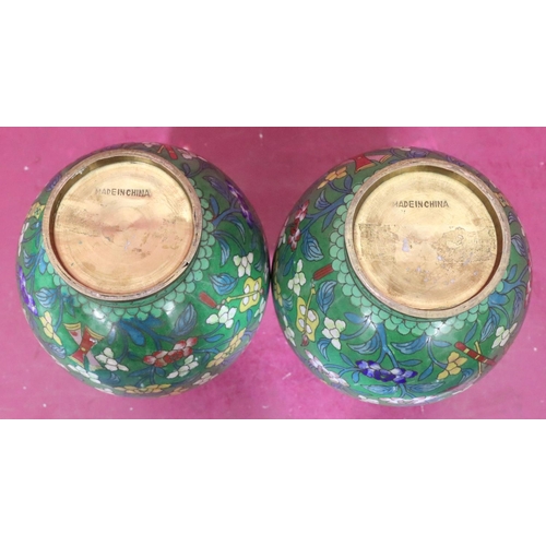 848 - A pair of Oriental cloisonné round bulbous thin necked vases on green ground with multicoloured flor... 