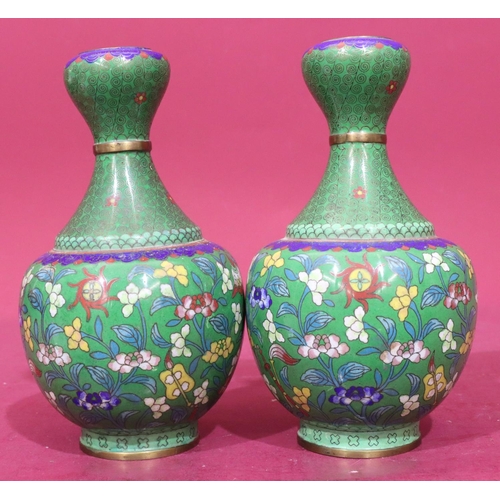 848 - A pair of Oriental cloisonné round bulbous thin necked vases on green ground with multicoloured flor... 