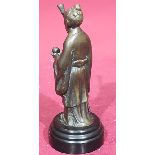 869 - A reproduction bronze figure of a standing Oriental gentleman holding a staff on black circular base... 