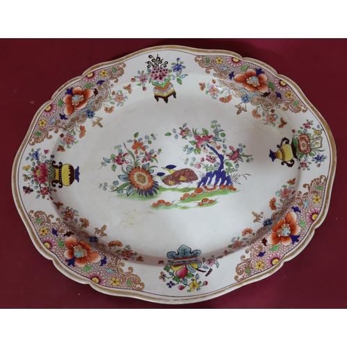 88 - A 19th Century oval scallop shaped meat plate on white ground with multicoloured bird, vase, floral,... 