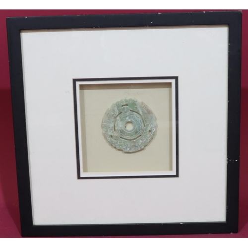 883 - A hardstone carved and pierced disc mounted in later black frame, 9cm diameter