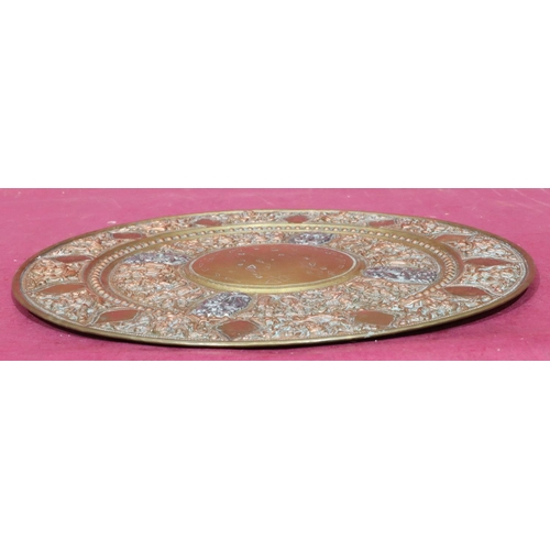 890 - A circular Eastern copper and brass tray with allover embossed figure, floral and scroll decoration,... 