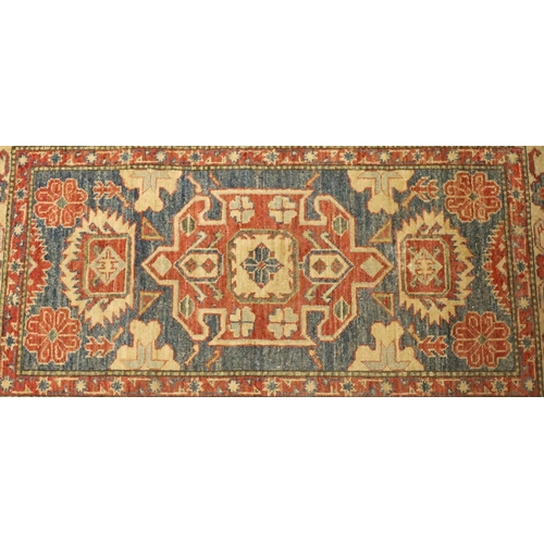 902 - A small Persian style rug on red, blue and cream ground with centre medallion surrounded by floral m... 