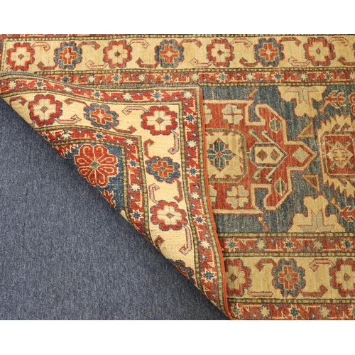 902 - A small Persian style rug on red, blue and cream ground with centre medallion surrounded by floral m... 