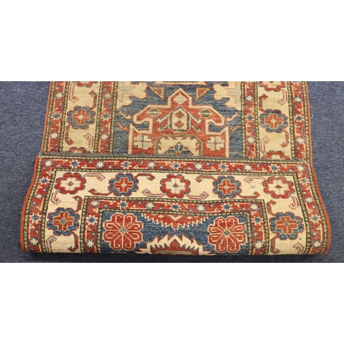 902 - A small Persian style rug on red, blue and cream ground with centre medallion surrounded by floral m... 