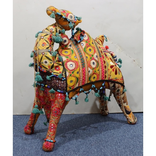 910 - A carpet floor standing camel on multicoloured ground, 74cm high, 73cm long