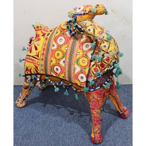 910 - A carpet floor standing camel on multicoloured ground, 74cm high, 73cm long