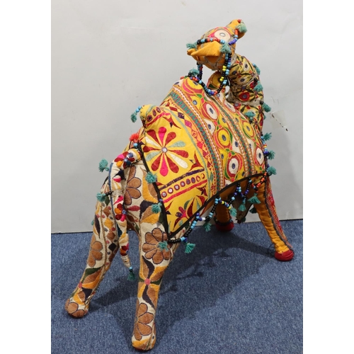 910 - A carpet floor standing camel on multicoloured ground, 74cm high, 73cm long