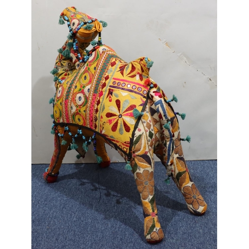 910 - A carpet floor standing camel on multicoloured ground, 74cm high, 73cm long