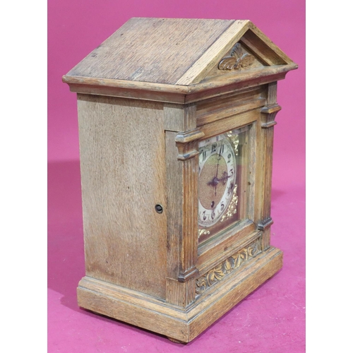 922 - An oak German 8-day striking mantel clock with carved raised floral and leaf decoration, reeded colu... 