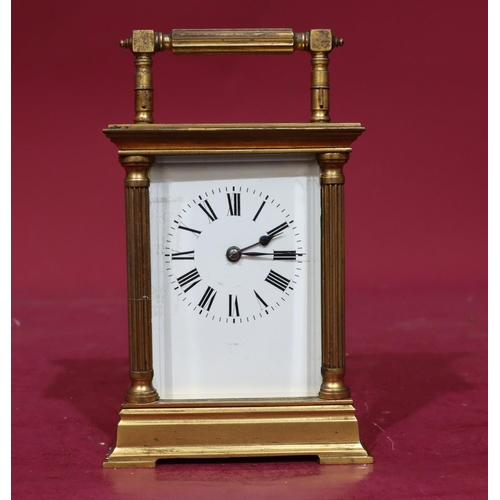 924 - A brass half-hour striking carriage clock with corinthian column supports, swing overhead handle, wh... 