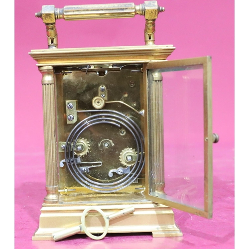 924 - A brass half-hour striking carriage clock with corinthian column supports, swing overhead handle, wh... 