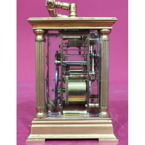 924 - A brass half-hour striking carriage clock with corinthian column supports, swing overhead handle, wh... 