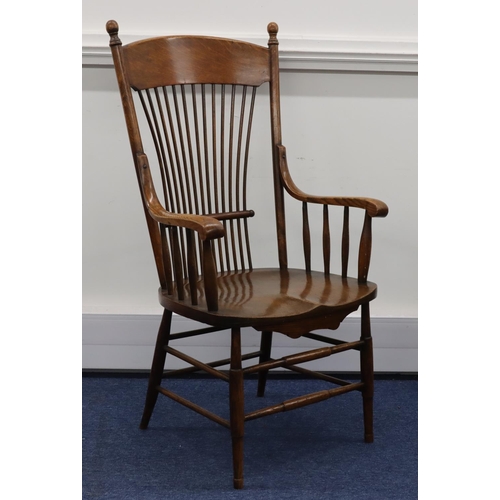 948 - An oak stick back armchair with solid seat on round tapering legs