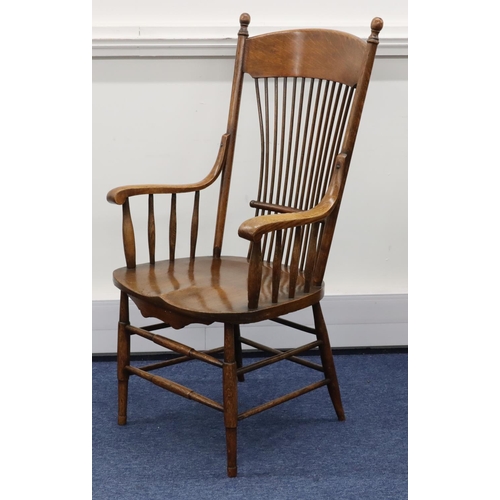 948 - An oak stick back armchair with solid seat on round tapering legs