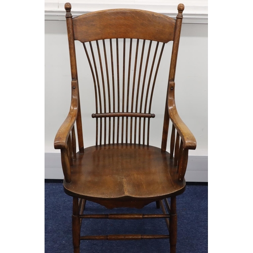 948 - An oak stick back armchair with solid seat on round tapering legs