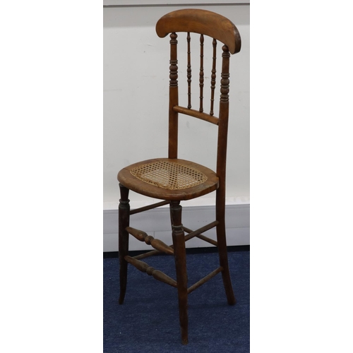 951 - A child's fruitwood tall back chair with spindle back and cane seat on round tapering legs, 105.5cm ... 