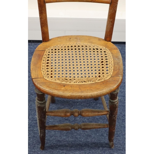 951 - A child's fruitwood tall back chair with spindle back and cane seat on round tapering legs, 105.5cm ... 