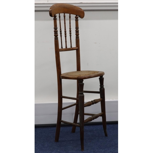 951 - A child's fruitwood tall back chair with spindle back and cane seat on round tapering legs, 105.5cm ... 