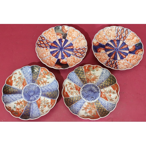 99 - A pair of Imari round scallop shaped plates on white, red and blue ground with butterfly, floral, le... 