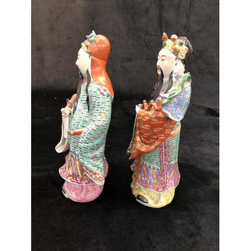 149 - A pair of Chinese glazed earthenware figures of gentleman with multicoloured cloaks, on hardwood sta... 