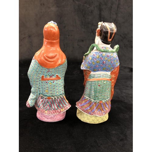 149 - A pair of Chinese glazed earthenware figures of gentleman with multicoloured cloaks, on hardwood sta... 