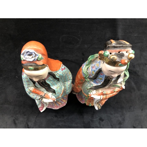 149 - A pair of Chinese glazed earthenware figures of gentleman with multicoloured cloaks, on hardwood sta... 