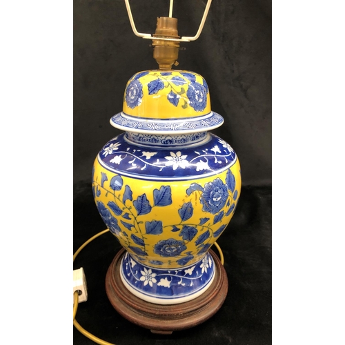 2151 - A blue, yellow and white glazed lamp with flower and leaf pattern, 36cm high on wood circular base