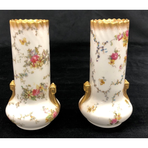 2157 - A pair of George Jones vases on white ground with multi-coloured floral and leaf pattern, 15cm high.