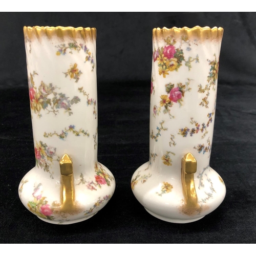 2157 - A pair of George Jones vases on white ground with multi-coloured floral and leaf pattern, 15cm high.