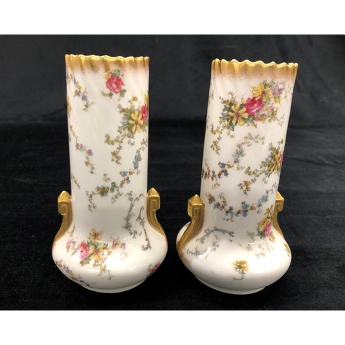 2157 - A pair of George Jones vases on white ground with multi-coloured floral and leaf pattern, 15cm high.