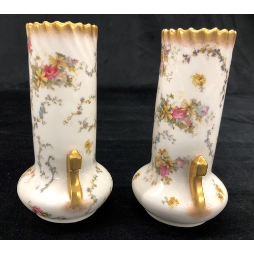 2157 - A pair of George Jones vases on white ground with multi-coloured floral and leaf pattern, 15cm high.