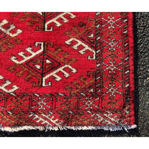 2203 - A small rug on red ground, 92cm wide, 110cm long and another smaller rug 62.5cm wide, 108cm long.