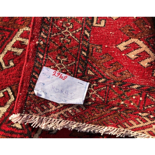 2203 - A small rug on red ground, 92cm wide, 110cm long and another smaller rug 62.5cm wide, 108cm long.