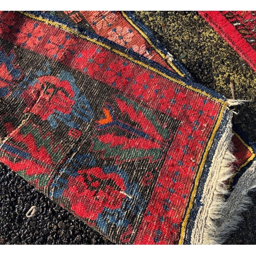 2203 - A small rug on red ground, 92cm wide, 110cm long and another smaller rug 62.5cm wide, 108cm long.