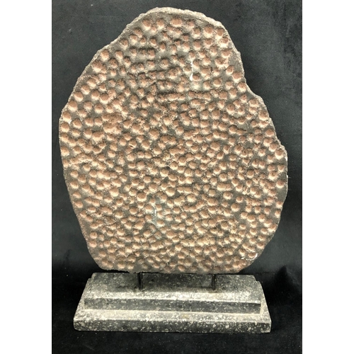 2249 - An Eastern stone effect figure on stone base, 25.5cm wide, 39.5cm high overall.