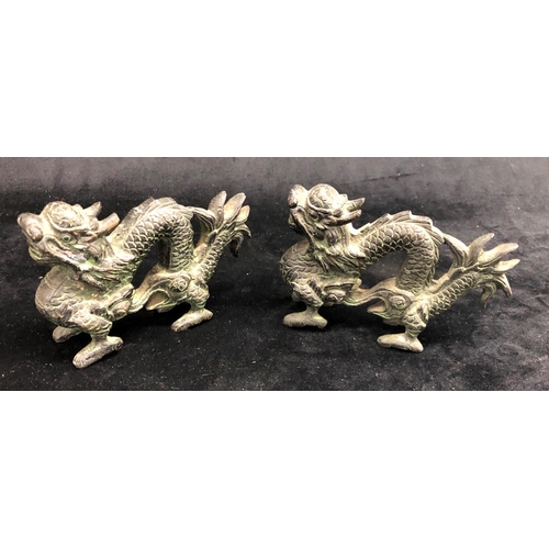 2292 - A pair of bronze Oriental dragons, 13.5cm wide, 9cm high and a pair of Oriental miniature clogs.