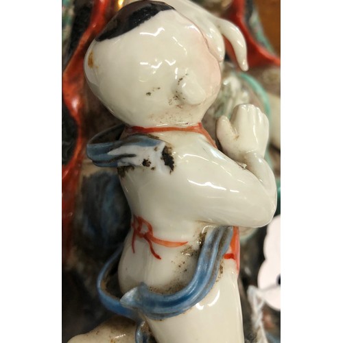 123 - An Oriental glazed earthenware figure of a seated goddess with child at her feet, 28.5cm high