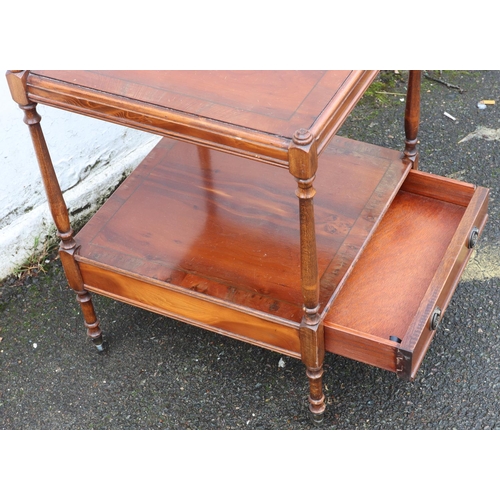 3086 - A reproduction yew 2-tiered occasional table with small drawer and brass handles, on castors 45 x45c... 