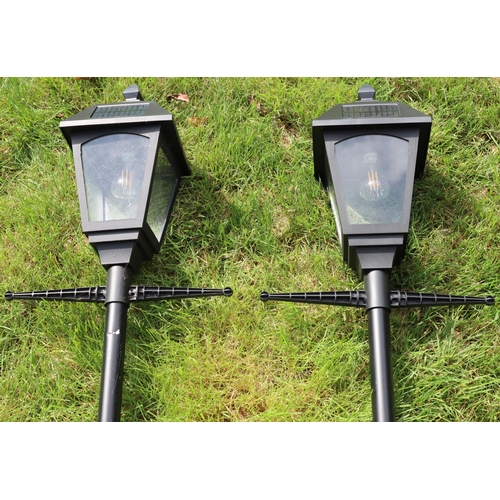 3130 - A pair of black metallic modern solar powered lantern style garden lights, 203cm high overall. (This... 