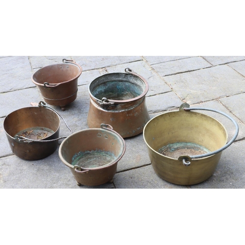 3164 - A quantity of copper and brass pots with swing overhead handles, largest 28cm diameter. (This item i... 