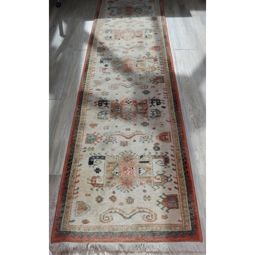 3122 - A long hall runner on cream ground, 64.5cm wide, 271cm long. (This item is not held by PF Windibank ... 