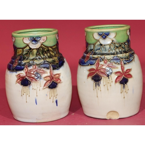 100 - A pair of Royal Doulton glazed earthenware round bulbous thin necked vases on white ground with mult... 