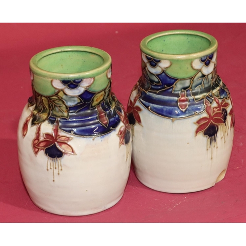 100 - A pair of Royal Doulton glazed earthenware round bulbous thin necked vases on white ground with mult... 