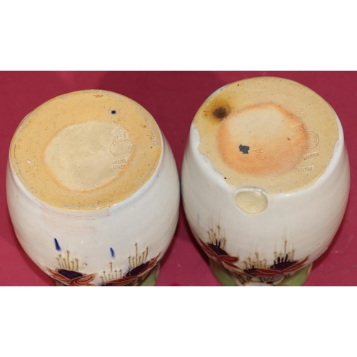 100 - A pair of Royal Doulton glazed earthenware round bulbous thin necked vases on white ground with mult... 