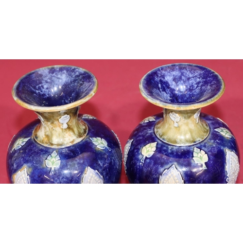 101 - A pair of Royal Doulton glazed earthenware round bulbous thin necked trumpet shaped vases on blue an... 