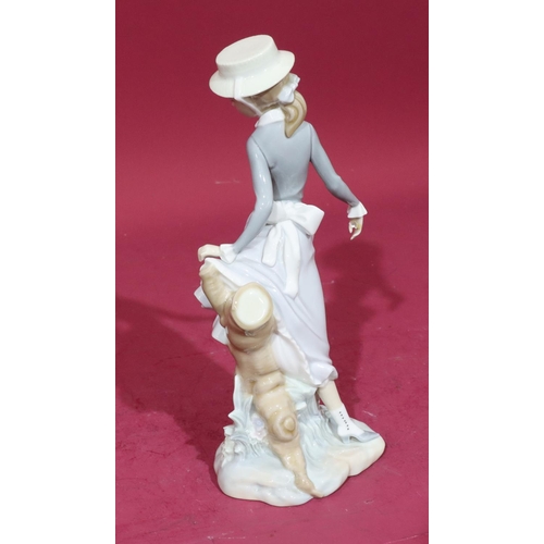 56 - A Lladro figure of a standing young lady next to tree trunk, 27.5cm high