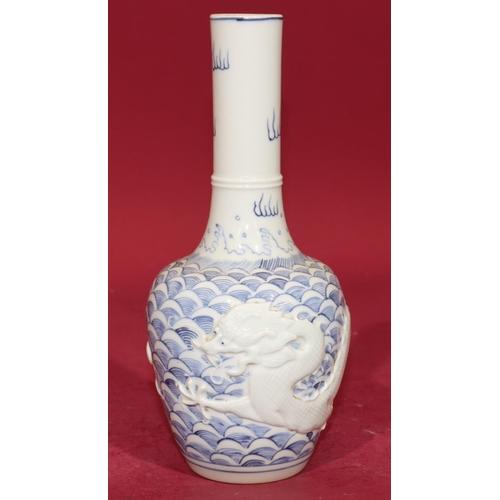 62 - An Oriental round bulbous thin necked vase on blue and white ground with raised dragon decoration, 2... 