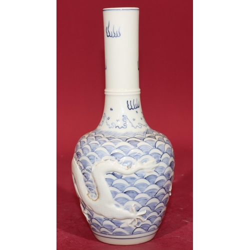 62 - An Oriental round bulbous thin necked vase on blue and white ground with raised dragon decoration, 2... 